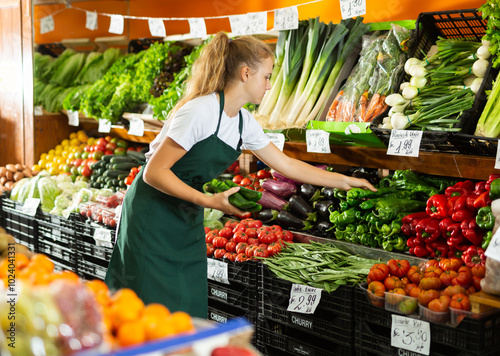 Obraz na plátně Focused fifteen-year-old girl who works part-time in a store as a trainee salesw
