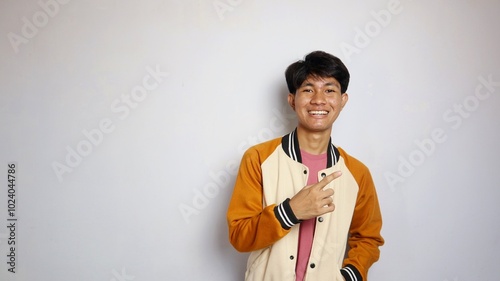 casual smiling young handsome asian man wearing jacket giving gesture pointing to the side photo