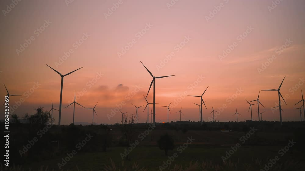 Beauty in nature of the windmill farm at sunset with the golden light of the sun beautiful. Renewable energy and green clean energy are environment friendly. Wind turbine for electric power ecology. Beauty in nature of the windmill farm at sunset with the golden light of the sun beautiful. Renewable energy and green clean energy are environment friendly. Wind turbine for electric power ecology.
