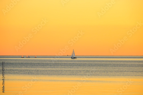 sailboat at sunset yellow orange hues room for text shot ashbridges bay toronto in fall photo