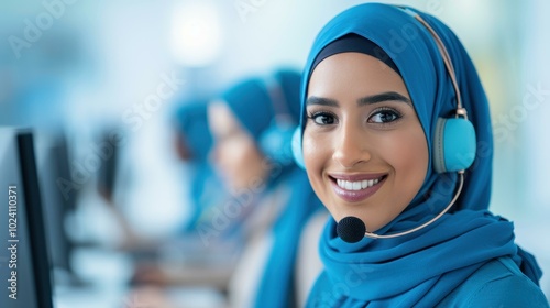 A devoted young woman in a hijab provides excellent customer support with her headset while using a computer.