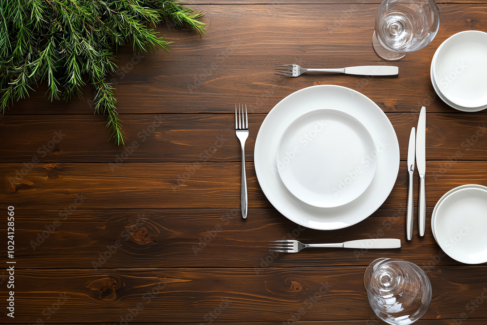 Dinner table setup with white dishes and cutlery Dinner table setup with white dishes and cutlery