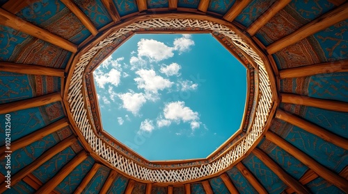 Gazing up at the intricate lattice roof of a nomadic yurt, blue sky dotted with clouds visible through the central opening, traditional details on full display photo