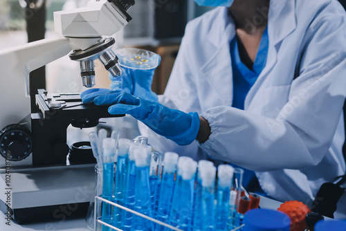 Scientist using microscope in laboratory. Close-up of a researcher's hands adjusting a modern microscope in a lab setting. Science concept