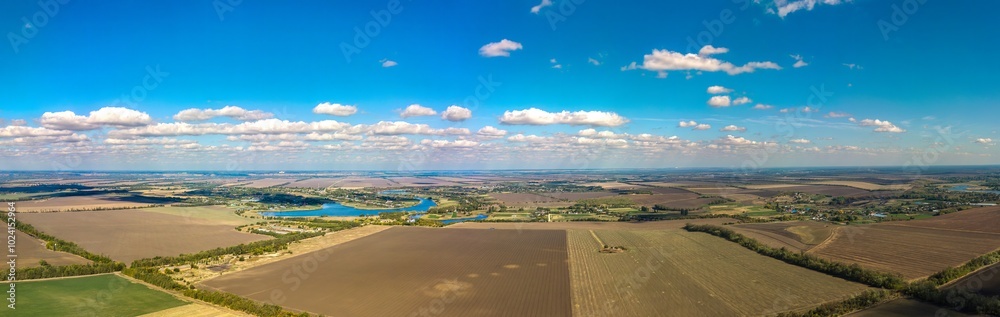 Fototapeta premium aerial panorama view of ponds and village Nekrasovskoye surrounded by autumn fields (South of Russia, Kuban) on a sunny day in October