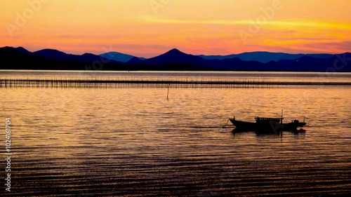 有明海の夕焼けと漁船。海苔養殖の風景