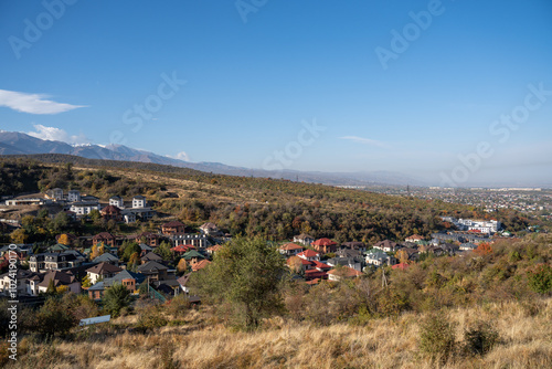 View of autumn village in the mountains, city against the backdrop of mountain landscape in autumn, houses in nature