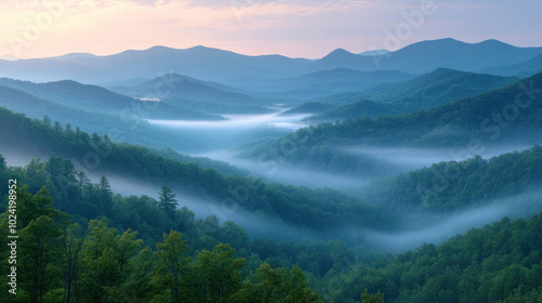 Foggy mountains at dawn, the mist softly flowing over the ridges and valleys, creating a serene and ethereal view