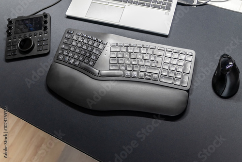 Ergonomic keyboard and ergonomic mouse as ergonomic home office equipment for freelance work and healthy workplace for notebook and clean desktop for efficient work from home for video editing graphic