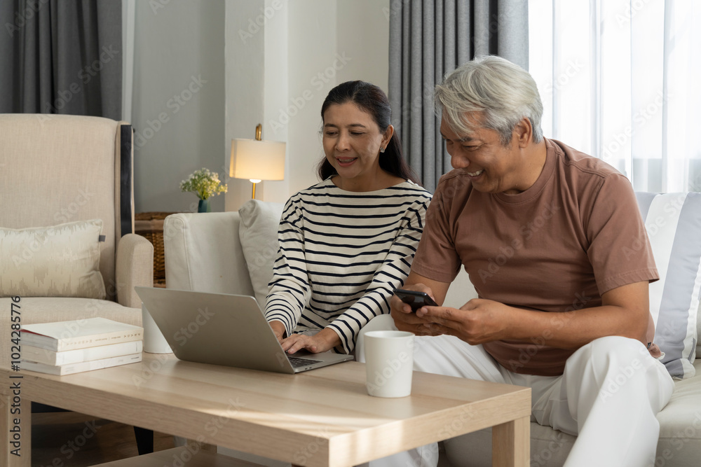Obraz premium Happily AsianCouple Looking at Laptop Together at Home