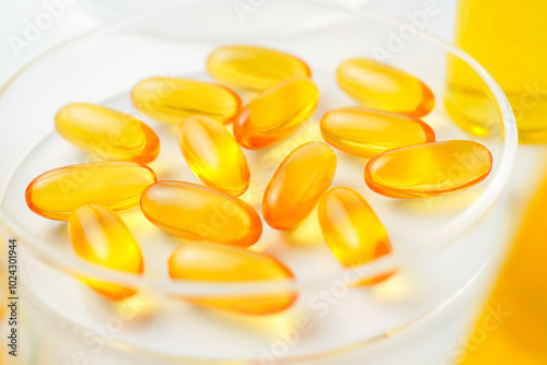 Petri dish with fish oil capsules inside, vitamin D, omega softgels, supplements, keto diet.