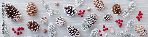 Frosted pinecones and red berries create festive winter scene, perfect for holiday decorations. arrangement evokes cozy, seasonal atmosphere