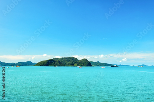 A beautiful view of Langkawi island against a beautiful blue sky with some boats in the distance on the horizon. Tropical scenery. located at Kedah, Malaysia - September 25 2024: