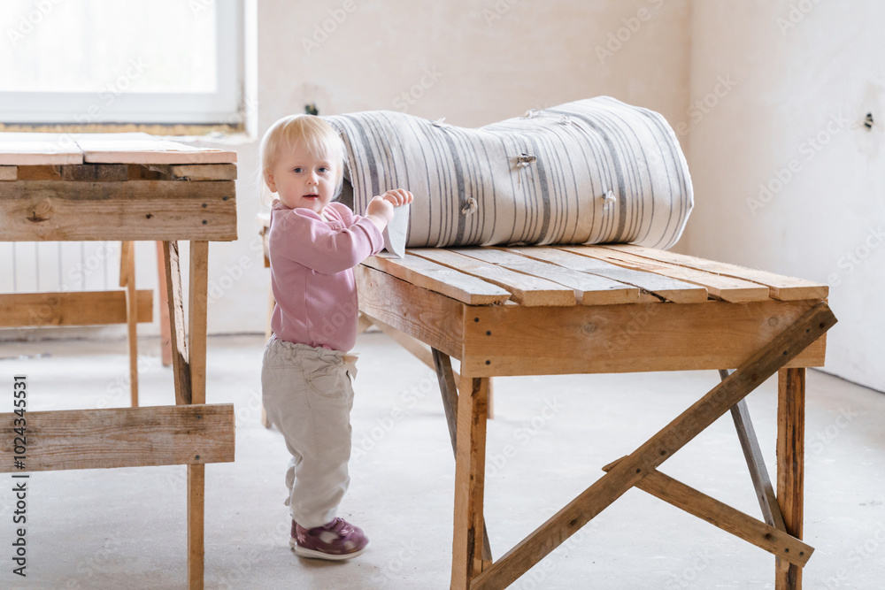 A little girl stands in an empty house where construction work A little girl stands in an empty house where construction work
