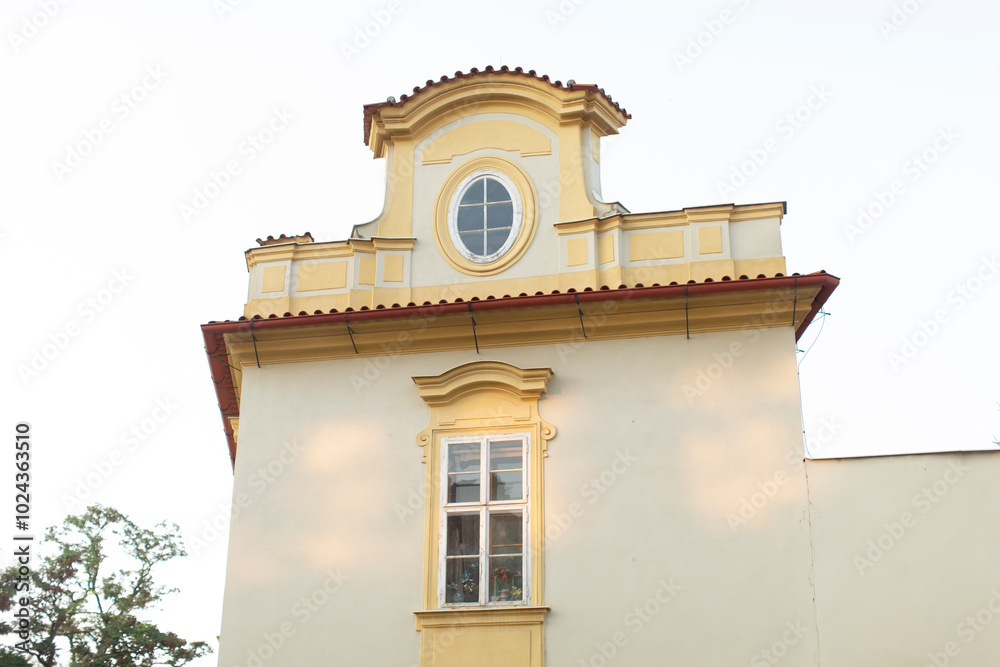 A striking white building adorned with a vibrant yellow roof and featuring a single window that adds to its charm and character A striking white building adorned with a vibrant yellow roof and featuring a single window that adds to its charm and character