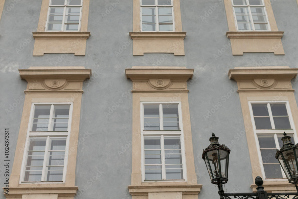 There is a large building that features numerous windows and has a charming lamp post positioned prominently in front of it There is a large building that features numerous windows and has a charming lamp post positioned prominently in front of it