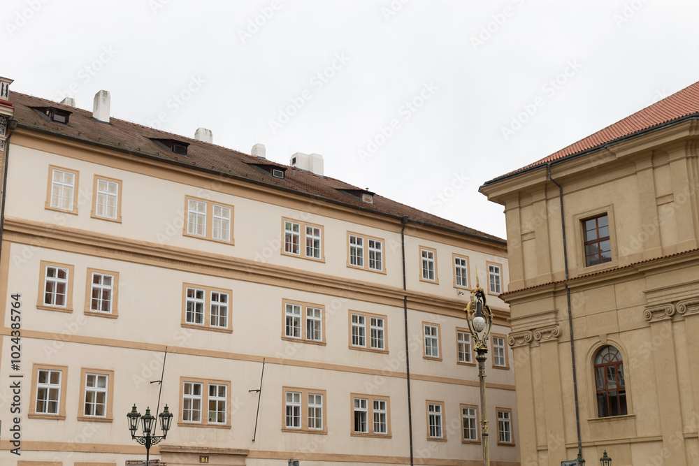 Fototapeta premium A sizable and impressive structure that features numerous windows and boasts a striking red roof, standing prominently amidst the skyline
