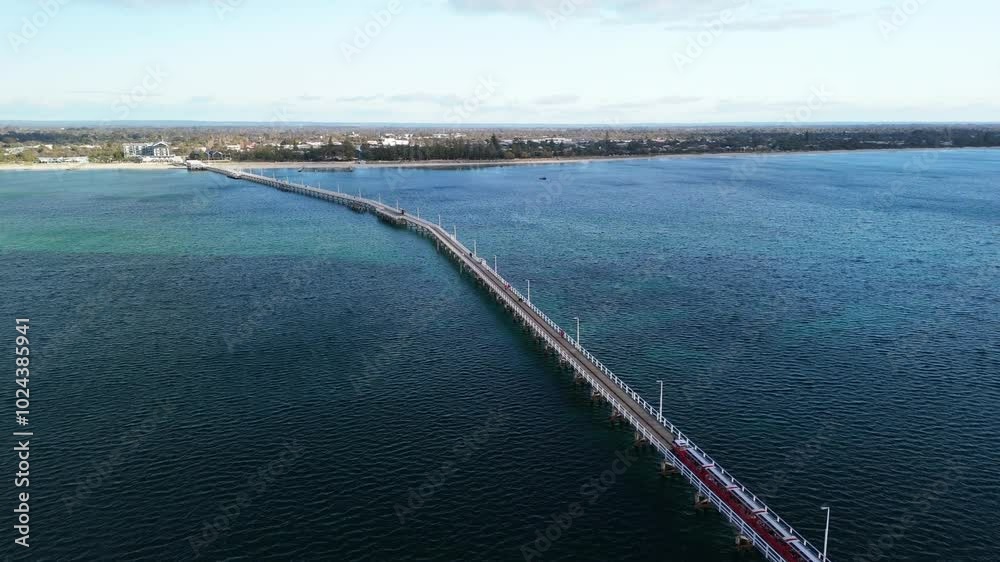 Drone zooming out over Busselton Jetty pier as the tourist train drives along the tracks Drone zooming out over Busselton Jetty pier as the tourist train drives along the tracks