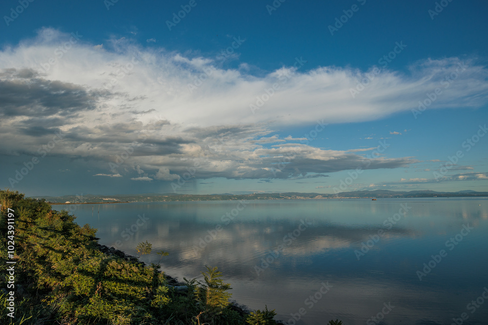 Obraz premium ampia vista panoramica sull'area marina del Golfo di Trieste, nel mare Adriatico e sulla costiera, con le colline e le montagne slovene distanti, al passaggio di un temporale pomeridiano