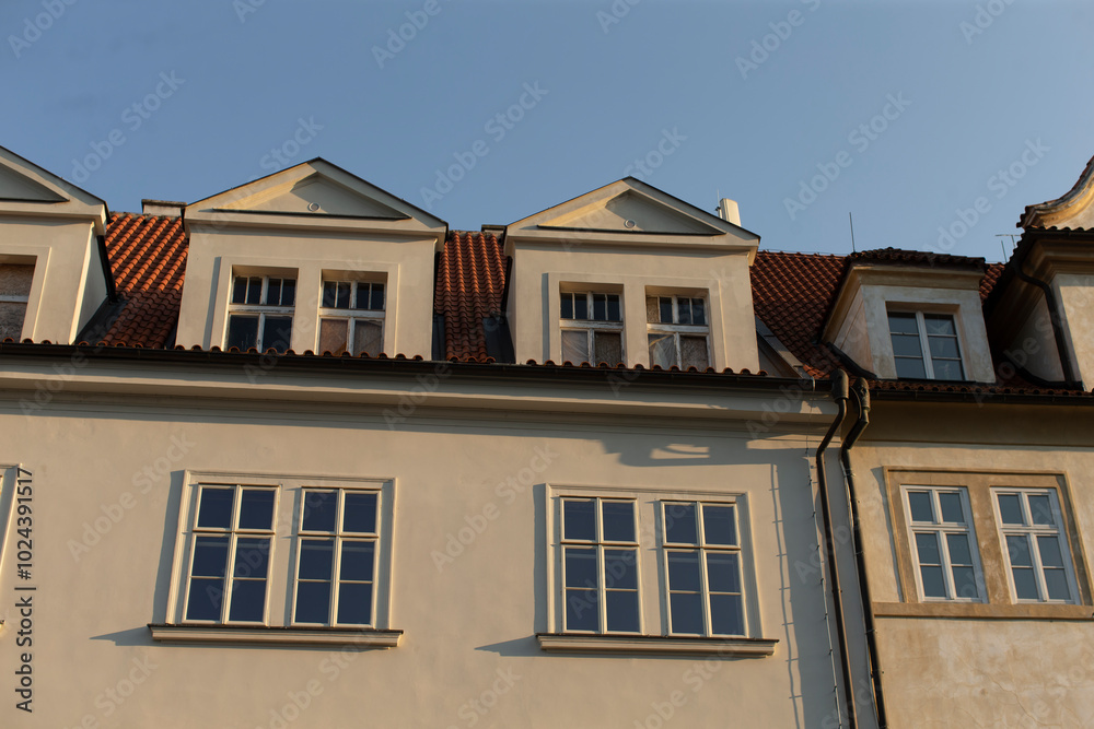 Fototapeta premium This is a charming building characterized by its red tiled roof and numerous windows that allow ample light to enter and enhance its design
