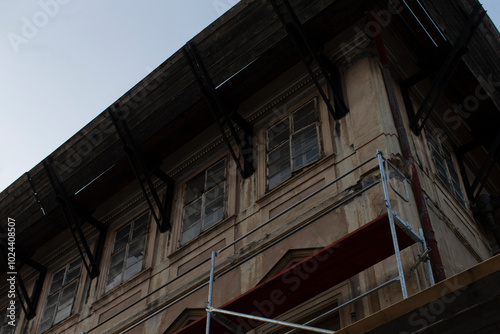 A large multistory building that has scaffolding attached to the side of it, indicating ongoing construction or renovation work being done