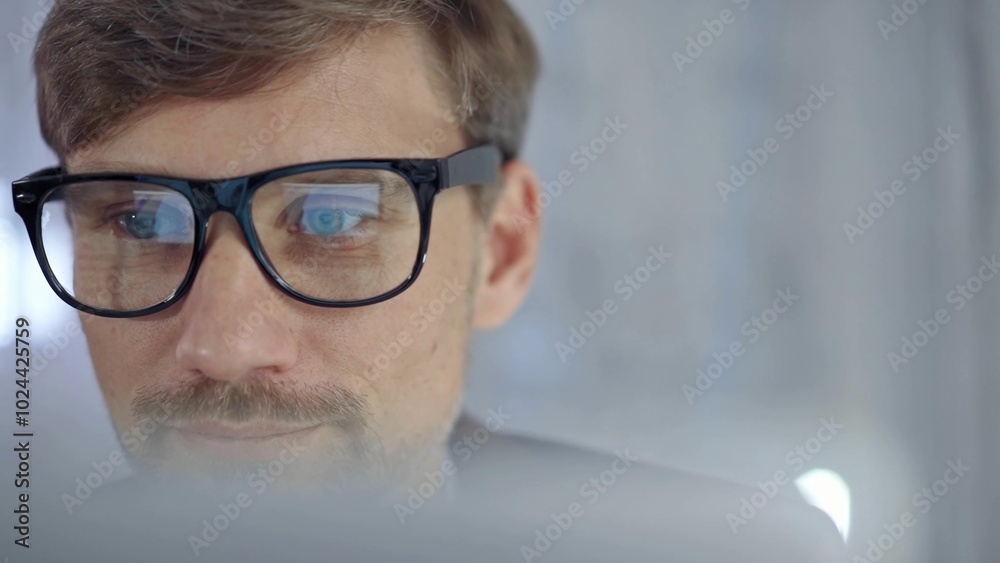 Businessman with glasses looking intently obscured partially by a translucent surface of laptop. Business people concept Businessman with glasses looking intently obscured partially by a translucent surface of laptop. Business people concept