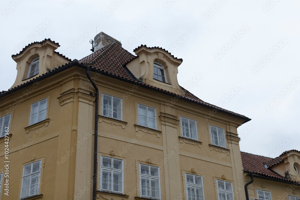 A considerably large yellowcolored building that features a distinct red tile roof, which adds to its charming appearance