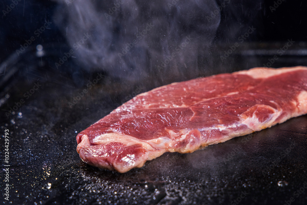 生の牛肉を鉄板で焼く様子 生の牛肉を鉄板で焼く様子