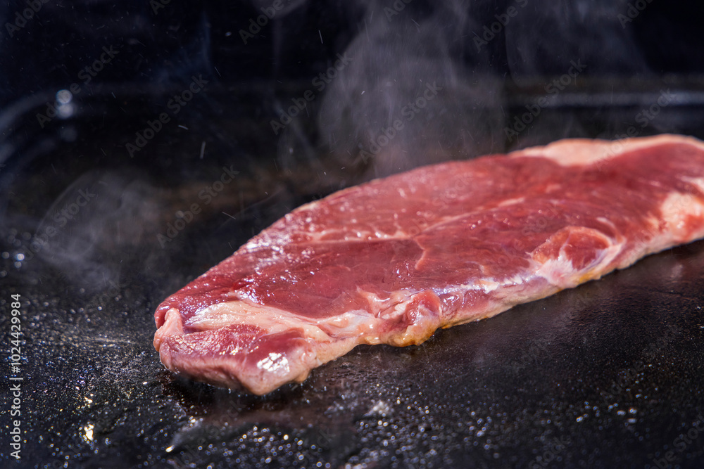 生の牛肉を鉄板で焼く様子 生の牛肉を鉄板で焼く様子