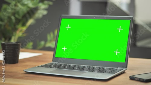 laptop computer green screen on wooden table in the modern home                              