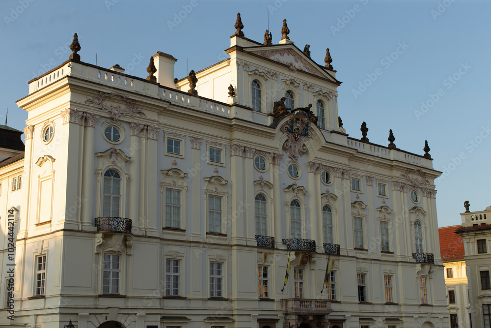 In the foreground, a large white building prominently stands against a bright blue sky that serves as the perfect backdrop for this scene In the foreground, a large white building prominently stands against a bright blue sky that serves as the perfect backdrop for this scene