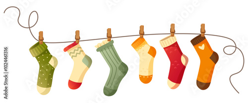 Beautiful different socks hang on a rope, secured with a clothespin. Washing, washed socks dry on a rope. Autumn and winter warm, woolen, knitted socks on a white background. An item of clothing.