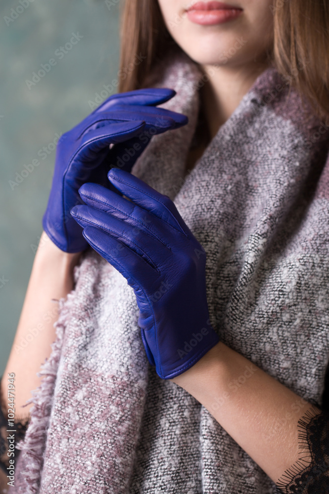 Beautiful woman in a warm scarf and blue leather gloves