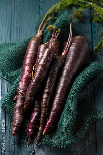 Obraz na płótnie A bunch of purple carrots are on a green cloth. w salonie