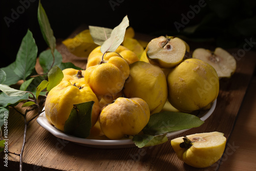 Obraz na płótnie Ripe yellow quince fruits on a plate on a wooden table w salonie