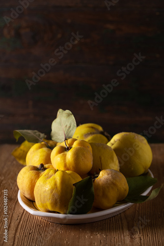 Ripe quince fruits on a plate on a table