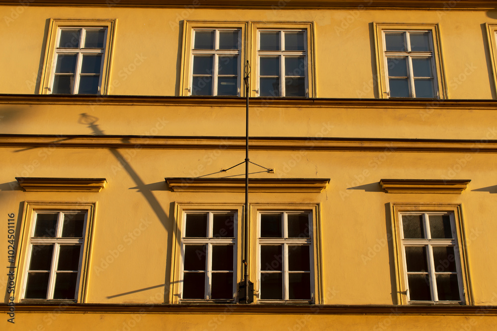 There is a striking yellow building that features numerous windows, giving it a vibrant and appealing look from all angles There is a striking yellow building that features numerous windows, giving it a vibrant and appealing look from all angles