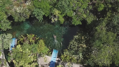 Aerial view of person jumping into cenote Nicte Ha in Parque Dos Ojos, Tulum, Riviera Maya, Mexico