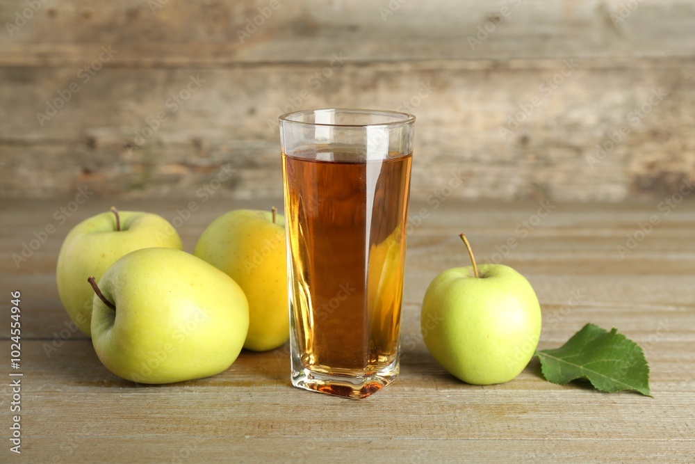 Glass of juice and apples on wooden table Glass of juice and apples on wooden table