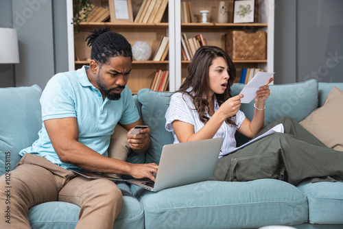 Home finance issues. Young couple having problem with utility bills, high prices and expenses, financial problems, paying bills online with credit card. Cost of living concept.