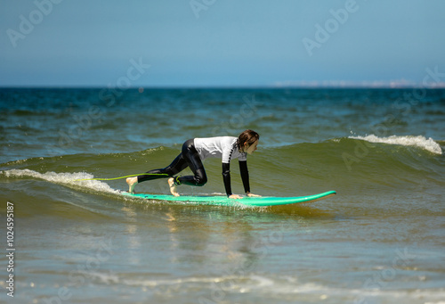 Photography Teenage girl learning to surf on foam in the ocean