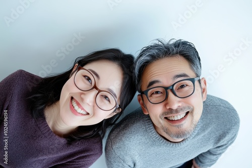 a couple dressed in matching purple on a white background with above view shot. Their posture symbolize unity, harmony, making it a heartwarming depiction of a lasting relationship.