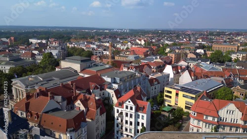 halle saale with the red brick building of the library surrounded by trees and houses, in germany. Stunning aerial view flight rotation to right drone photo