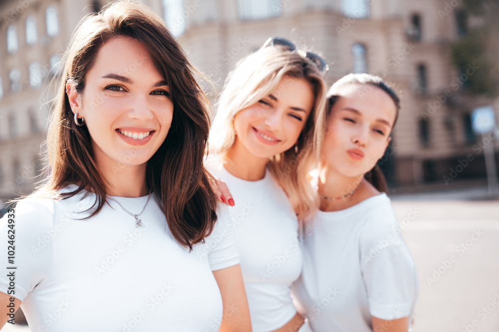 Obraz premium Three young beautiful smiling hipster female in trendy summer white t-shirt and jeans clothes. Sexy carefree women posing in the street. Positive models having fun, going crazy, closeup