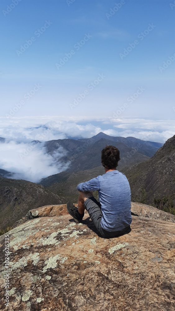 homem no alto do pico da bandeira, na divisa de minas gerais e espírito santo, com montanhas e mar de nuvens ao fundo homem no alto do pico da bandeira, na divisa de minas gerais e espírito santo, com montanhas e mar de nuvens ao fundo