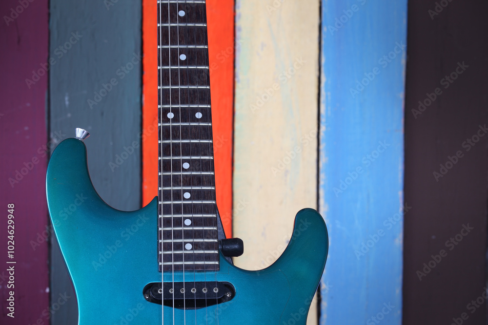 Obraz premium Vibrant Guitar Against Colorful Wooden Background