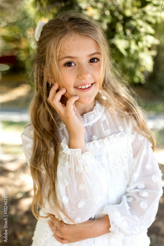 a young girl wearing a white dress with a bow on her head.