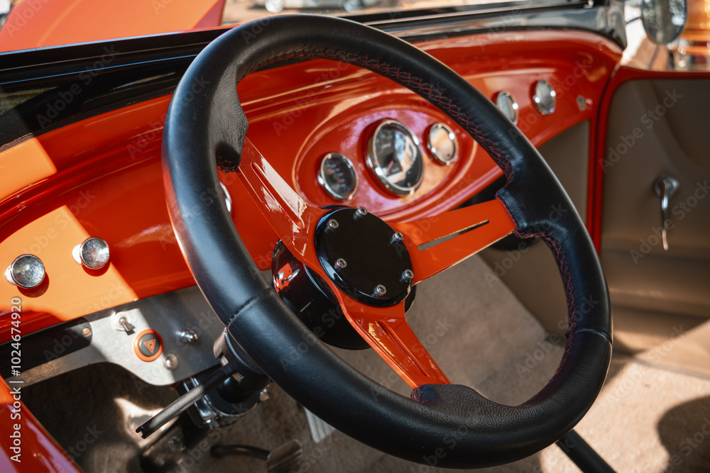 Detail of the dashboard of an old car with a sports steering wheel. Sunny daylight. Detail of the dashboard of an old car with a sports steering wheel. Sunny daylight.