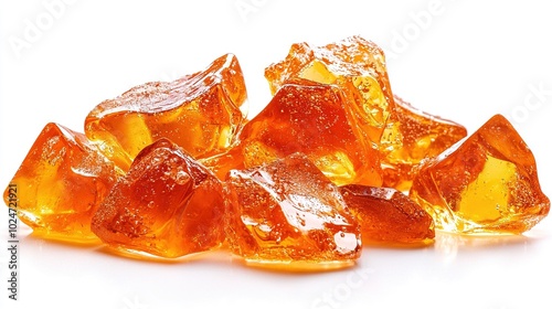   An array of orange gummy bears is neatly arranged atop a pristine white countertop alongside another batch of the same delicious treat