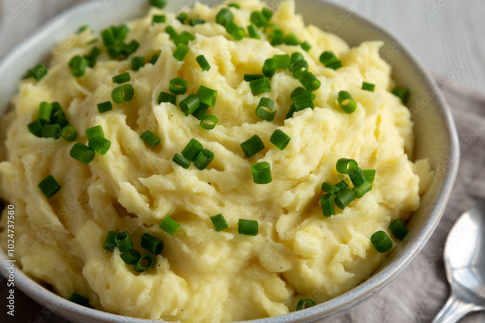Homemade Chive and Garlic Mashed Potatoes in a Bowl, side view. Close-up. Homemade Chive and Garlic Mashed Potatoes in a Bowl, side view. Close-up.